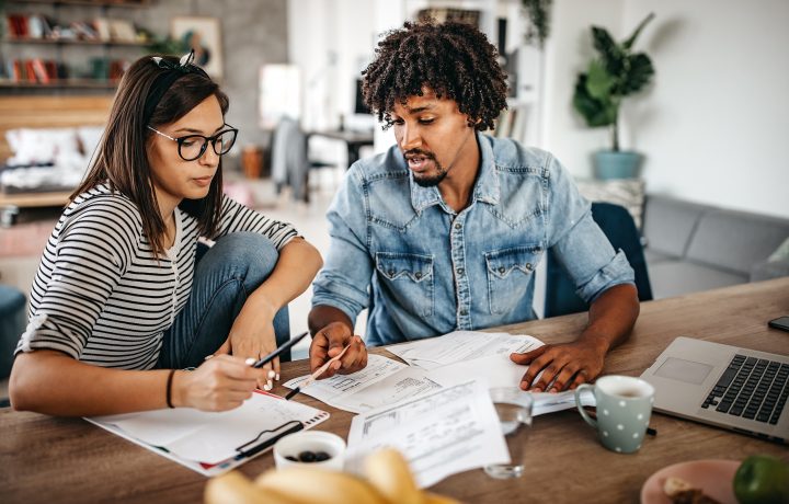A man and a woman discuss finances at a table