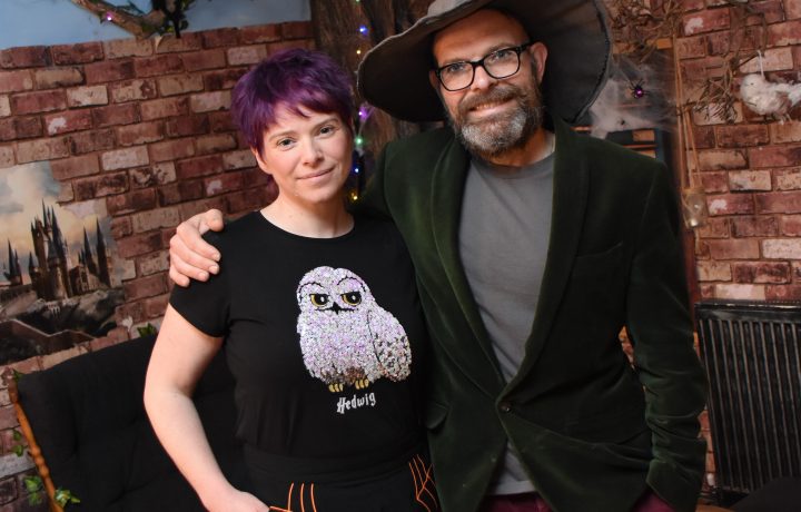 Rob and Nikki in front of a wizard-inspired display