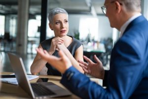 A smartly-dressed man and woman discussing business
